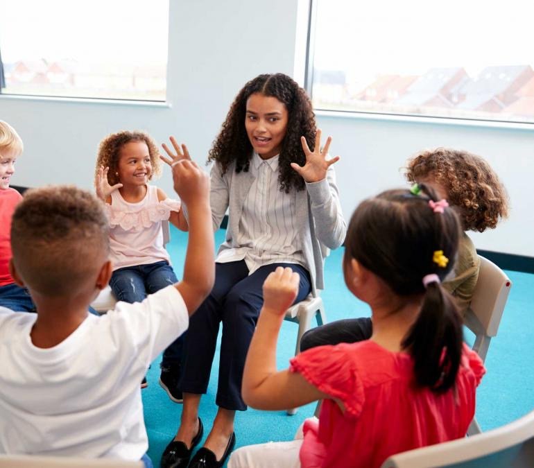 Black woman teacher working with a group of children