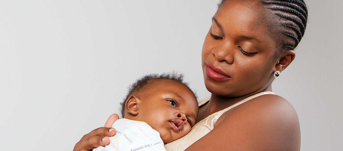A Black mother holding and gazing at her baby